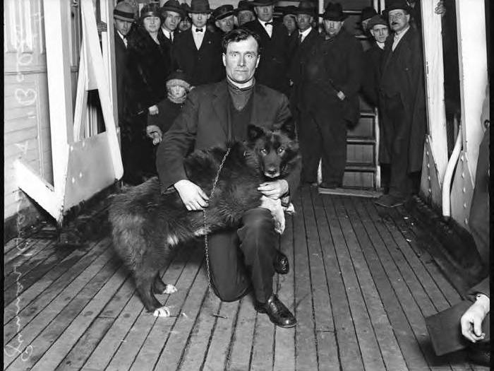 Musher Gunnar Kaasen in furs beside his lead dog Balto, 1925.
